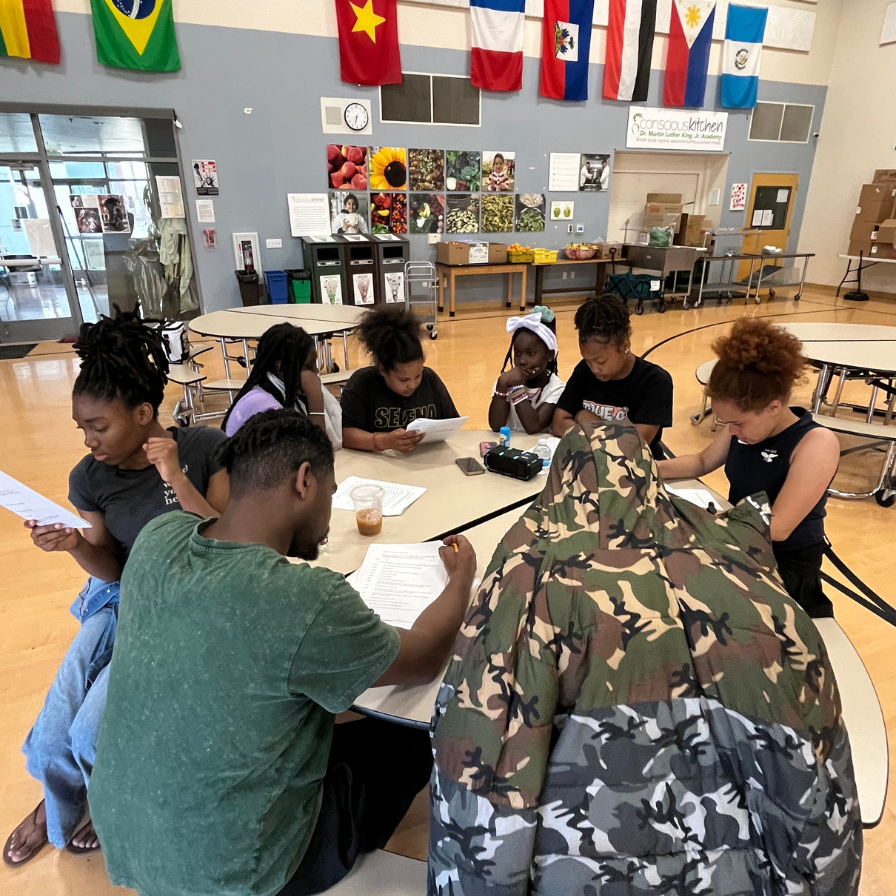 Griot team and actors reviewing play scripts at the table