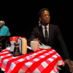 Andre sits a set table in character